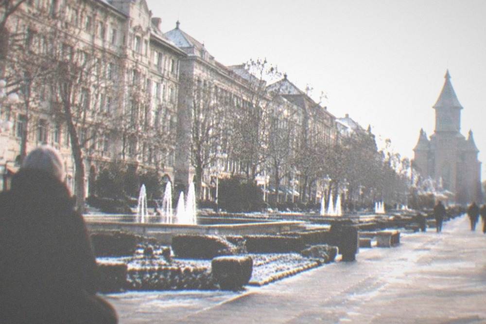 Winter street scene with bare trees, facades and people in heavy coats and hats