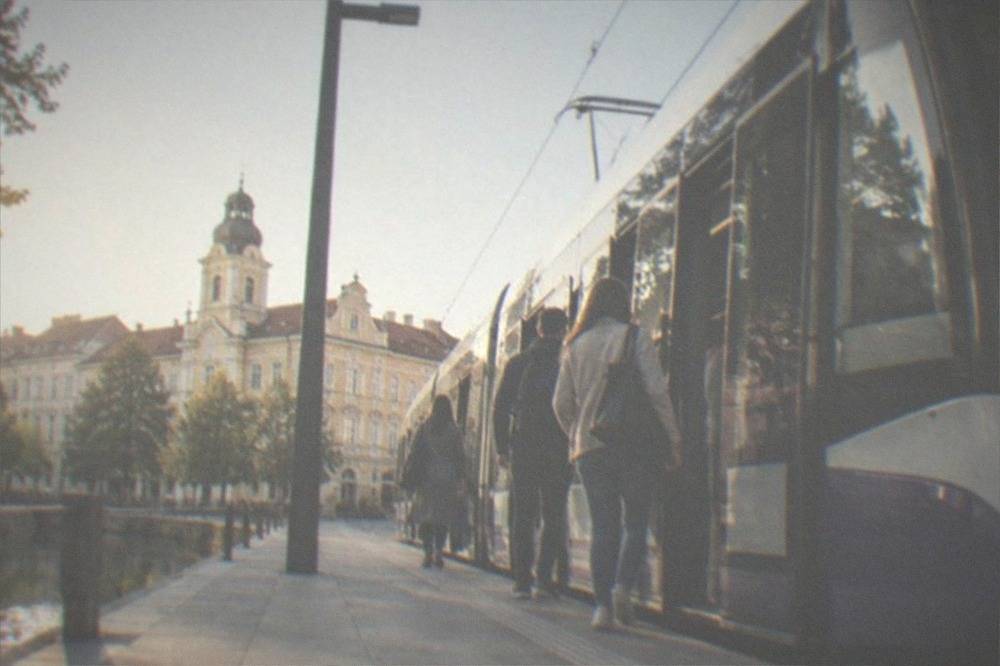 Passengers boarding a modern tram at a stop in central Timisoara