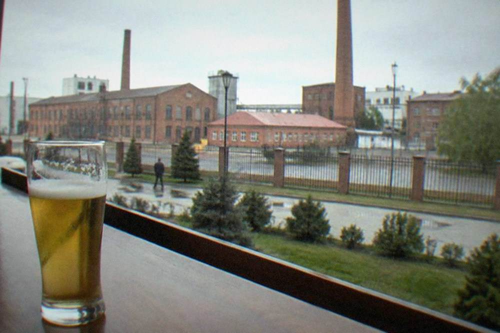 A half-liter glass of pale beer on a pub bar counter