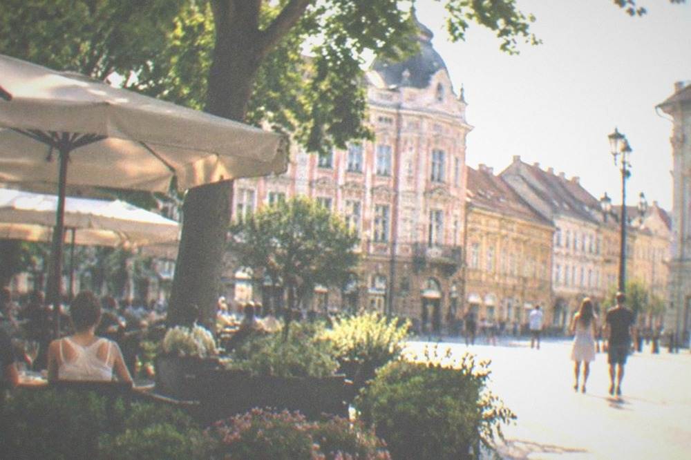 A hotel terrace with tables and planters on a warm evening in Timisoara's old town