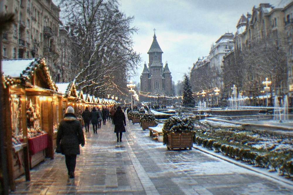 Christmas Market stalls and string lights in Victory Square in Timisoara at dusk