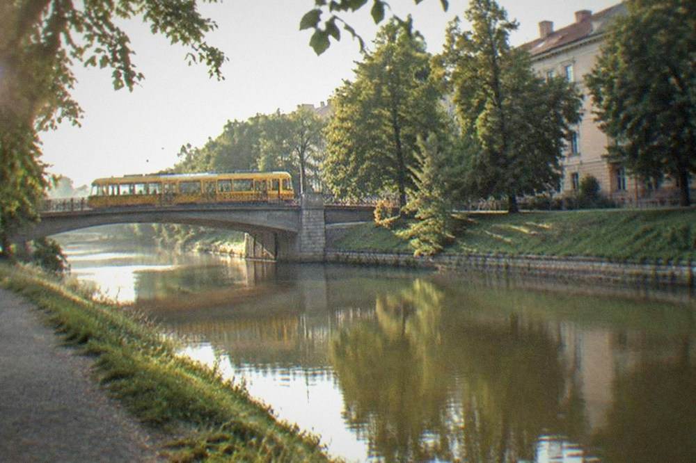 A yellow tram crossing a bridge over the Bega canal in central Timisoara