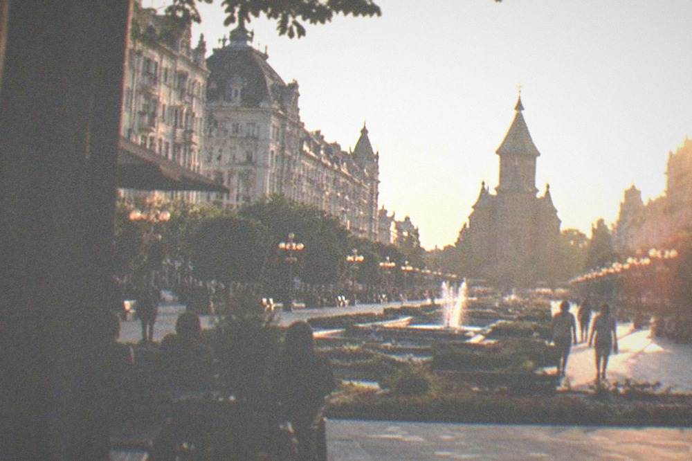 Evening lights along Piata Victoriei with the Opera building and promenade