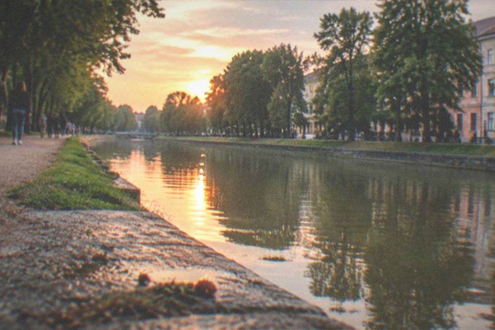 People strolling along the landscaped banks of the Bega canal at sunset