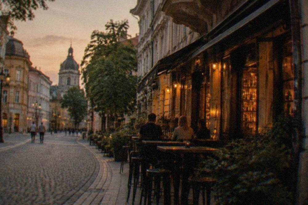 Narrow old town street at night with warm light spilling from bar windows