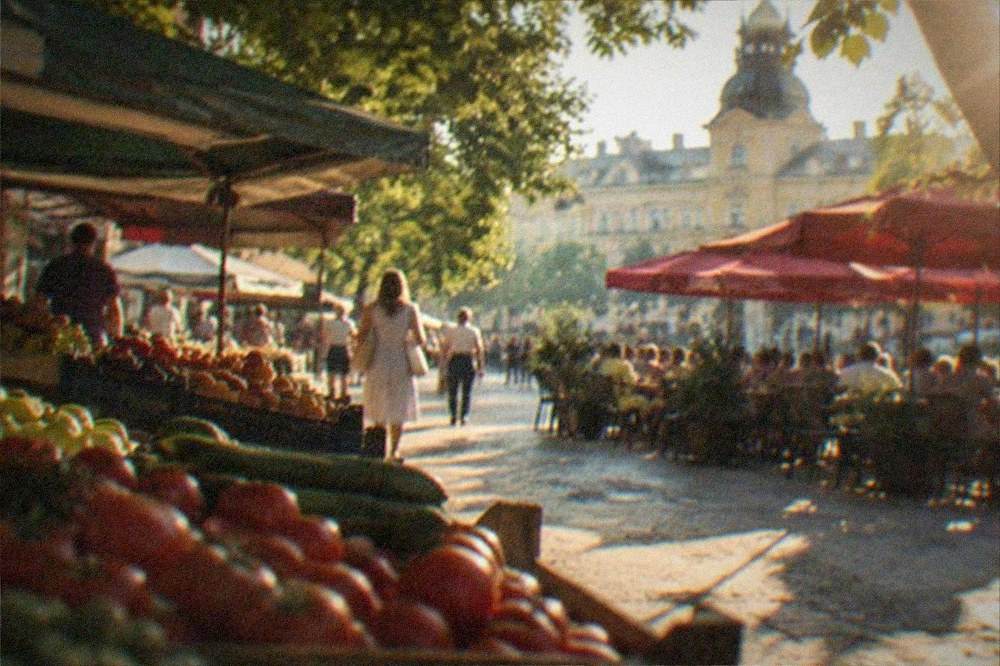 A terrace with red umbrellas and full tables on a city square in summer