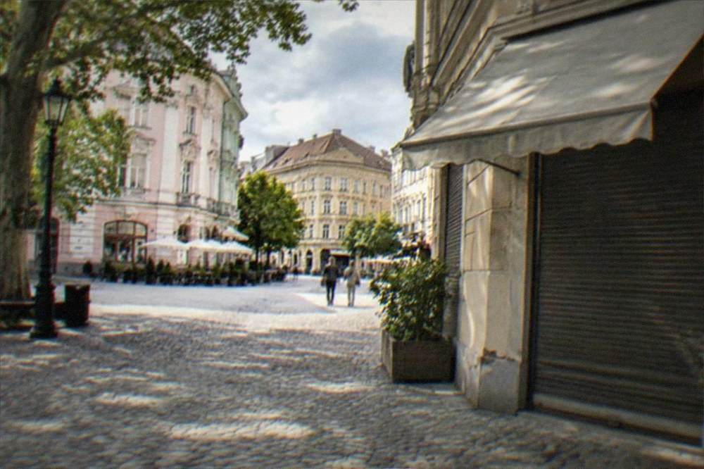 A closed storefront with an awning and a hand-written hours sign in Timisoara's old town