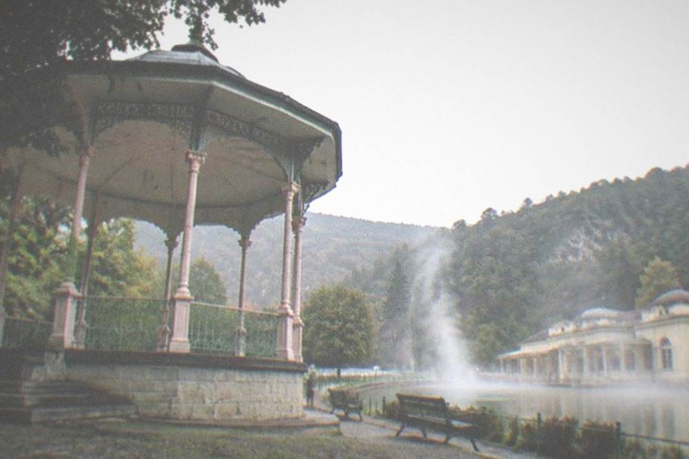Thermal steam rising above a mountain valley pool at an old spa resort in western Romania