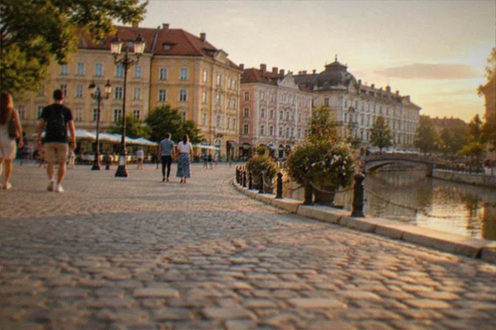 Visitors walking across a baroque square with pastel facades in central Timisoara