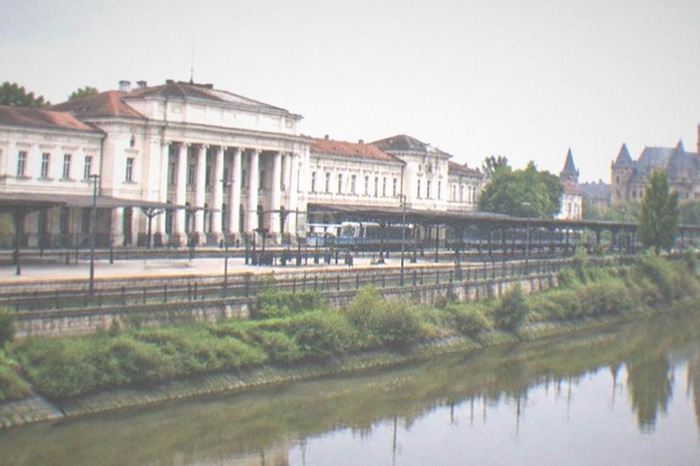 A Gothic castle with tall towers reflected beside a river