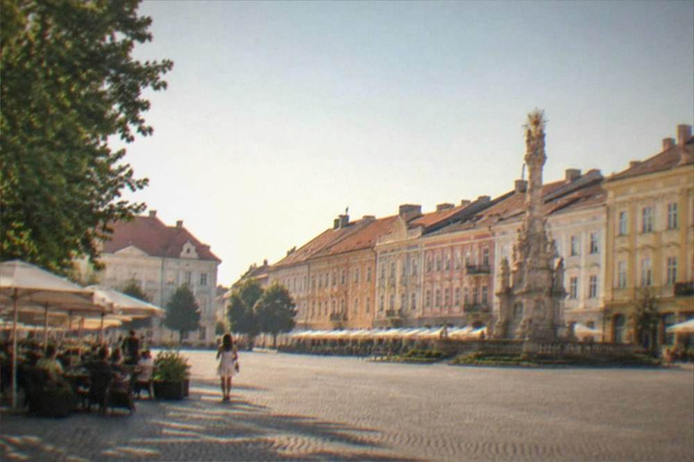 A summer view of Piata Unirii in Timisoara with outdoor cafe tables and historic buildings