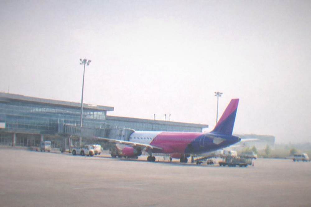 A Wizz Air aircraft parked at a gate at Timisoara Traian Vuia airport in daylight