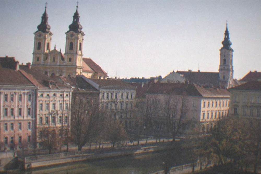 Two church towers rising above red rooftops seen from an elevated viewpoint