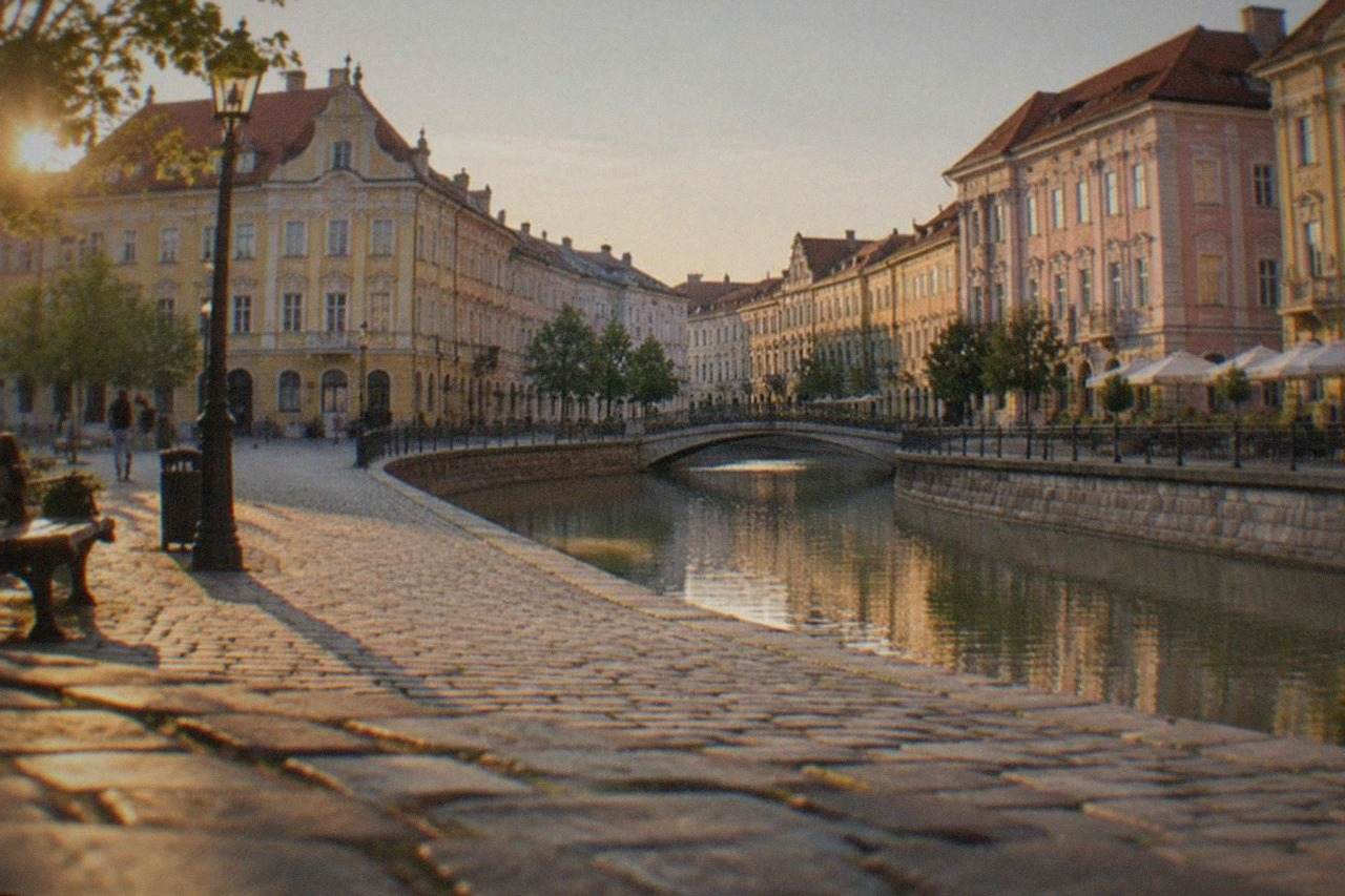 Colorful baroque facades around a wide pedestrian square in Timisoara at golden hour