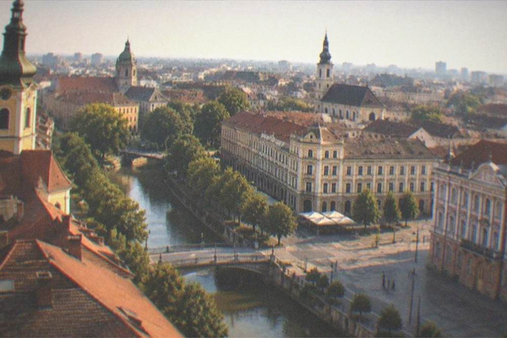Aerial view of rooftops and church spires across a historic city center