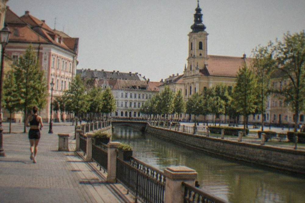 Historic buildings and a church tower seen from a square in Timisoara's old town