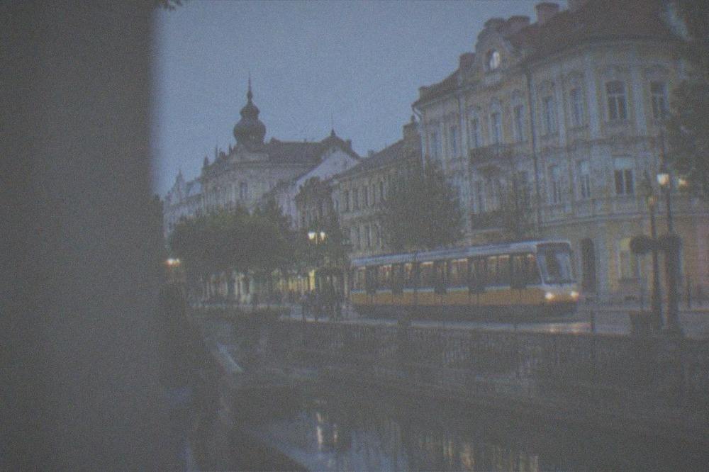 A tram passing ornate buildings on a street in central Timisoara