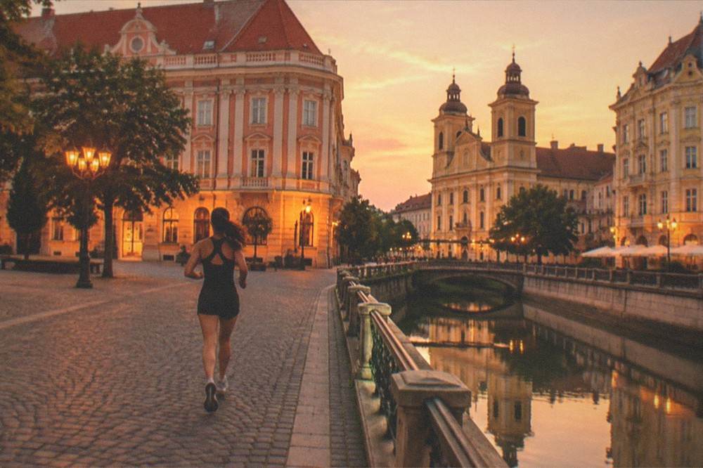 Illuminated historic buildings around a square in Timisoara at dusk