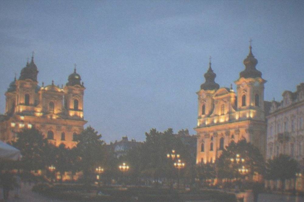 Two illuminated cathedrals facing each other across a decorated old town square