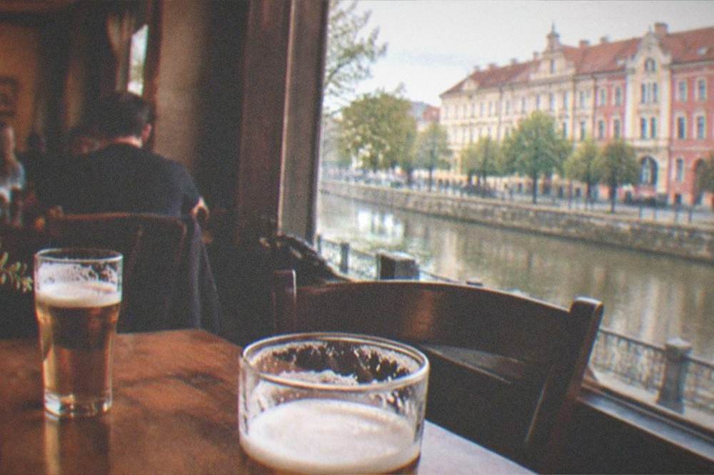 Warm light inside a cozy tavern with wooden tables and full glasses of beer