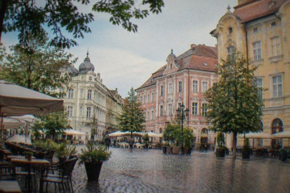 Cobbled square with colorful baroque facades and outdoor cafe tables