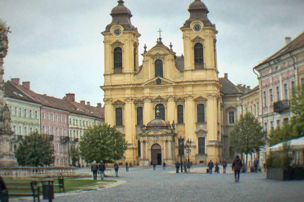 Ornate baroque cathedral facade with twin towers seen from a cobbled square