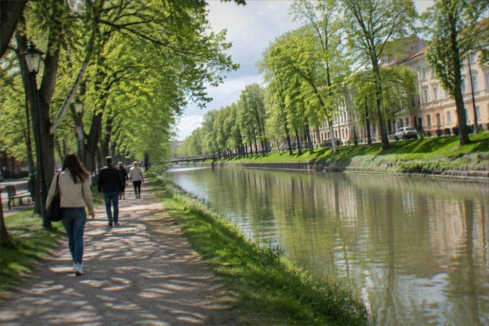 Visitors strolling along the Bega canal promenade in Timisoara in late spring